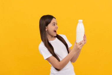 Hayretler içindeki çocuk süt ürünlerini elinde tutuyor. Genç kız süt içecek..