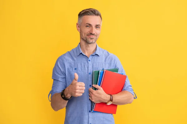 Homem feliz segurar notebook escola ou planejador mostrando polegar para cima, educação — Fotografia de Stock