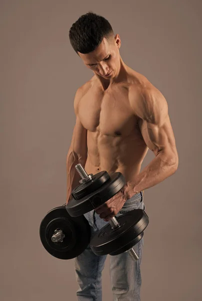 腕の強さと両足の筋肉を開発.強力な男はダンベルを持ち上げる。筋力トレーニングワークアウト — ストック写真