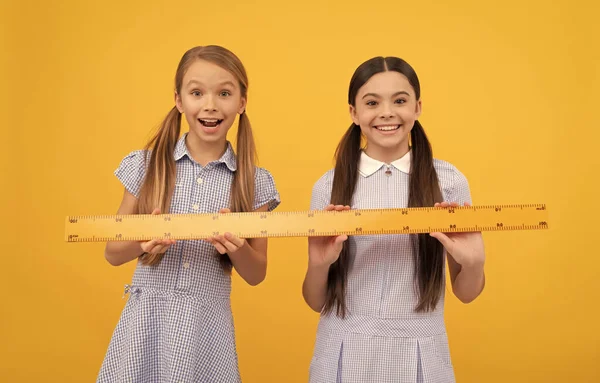 Los escolares felices tienen una regla de madera. Lección de geometría. Educación escolar. Regreso a la escuela —  Fotos de Stock