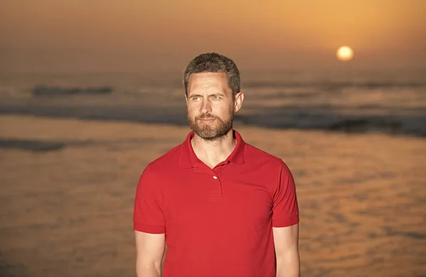 Tipo sem barba no fundo da praia. caucasiano na praia do nascer do sol. homem barbudo na camisa. — Fotografia de Stock