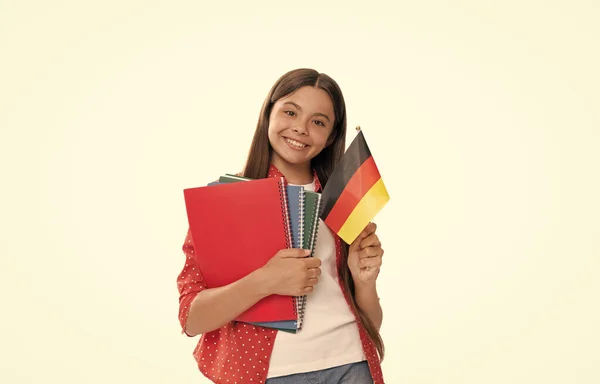 Χαρούμενο παιδί κρατά γερμανική σημαία και το σχολικό βιβλίο για τη μελέτη απομονωμένο σε λευκή, ξένη γλώσσα — Φωτογραφία Αρχείου