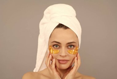 Altın anti-yorgunluk maskesi takıyorum. Kız göz torbalarını küçültür. Cilt bakımı. yüz kolajeni kozmetiği.