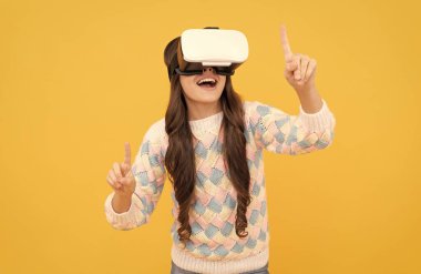 Mutlu genç kız sanal gerçeklikte eğitim için geleceğin teknolojisini kullanarak VR gözlükleri takıyor.