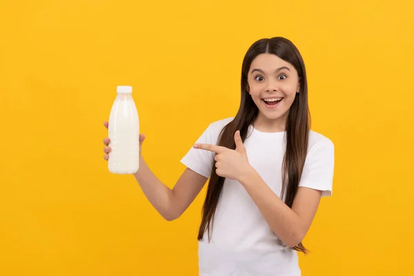 Έκπληκτος παιδί σημείο δάχτυλο στο γαλακτοκομικό προϊόν ποτών. έφηβος κορίτσι πρόκειται να πιει γάλα. — Φωτογραφία Αρχείου