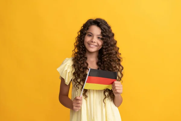 Uśmiechnięty dzieciak długie kręcone włosy trzymać niemiecką flagę, niemiecki — Zdjęcie stockowe