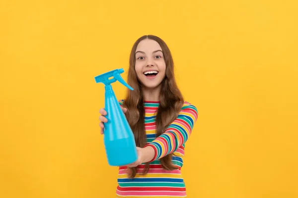 Happy girl chid show désinfectant pulvérisateur bouteille pour l'espace de copie fond jaune, nettoyage. — Photo