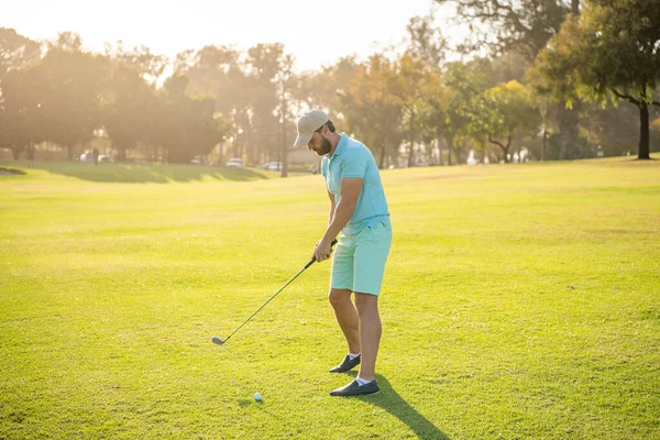Άντρας παίκτης του γκολφ σε επαγγελματικό γήπεδο γκολφ. πορτρέτο του παίκτη του γκολφ στο καπέλο με μπαστούνι του γκολφ. — Φωτογραφία Αρχείου