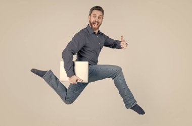 Bilgisayarda çalışırken zıplayan adam. Alışveriş için acele et. Başparmak yukarı, başarı..