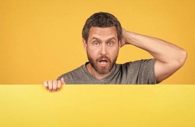 Şok olmuş, şaşırmış suratlı, sarı kağıdın arkasında fotokopi alanı için şaşırmış bir adam.