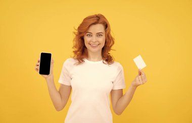 Çevrimiçi alışveriş yapmak için kredi kartı ve akıllı telefon gösteren mutlu kadın, çevrimiçi bankacılık.