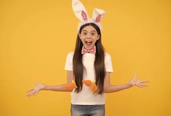 Surpresa Páscoa adolescente menina em orelhas de coelho e laço segurar cenoura, Páscoa — Fotografia de Stock