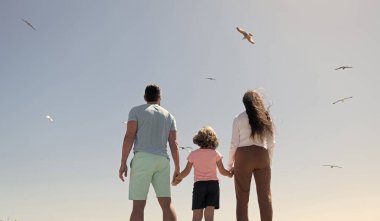 Anne, baba ve çocuğun ailesi gelecekte el ele tutuşacak. Yaz, arka manzara, yaz tatili..