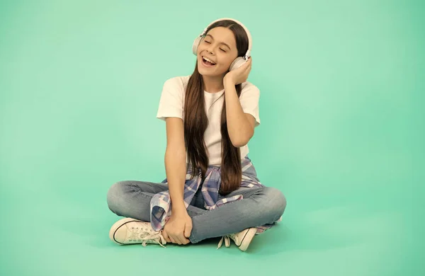 Χαρούμενο κορίτσι παιδί ακούει μουσική σε ασύρματα ακουστικά, σύγχρονα ακουστικά — Φωτογραφία Αρχείου