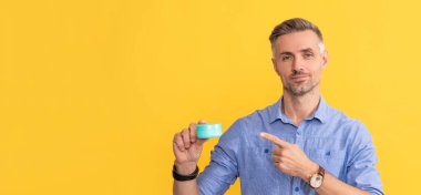 Adam saç maskesi ya da cilt kremi tutuyor. Günlük alışkanlık ve kişisel bakım. Cilt güzelliği.