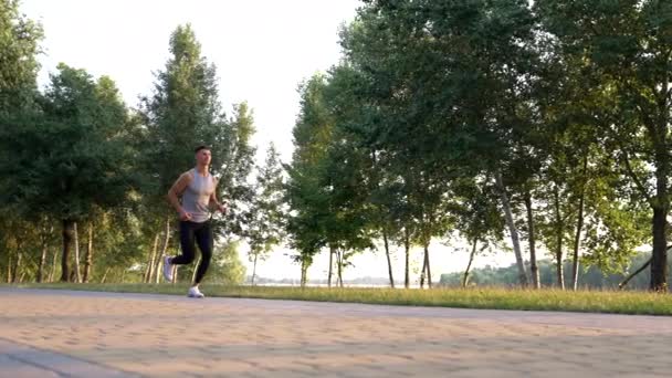 Открытая тренировка спортсмена бегущего в парке, бегуна — стоковое видео