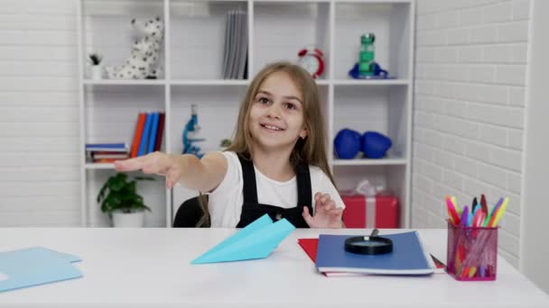 Sonriente adolescente chica divertirse jugando con avión de papel en la escuela lección en el aula, escolar — Vídeo de stock