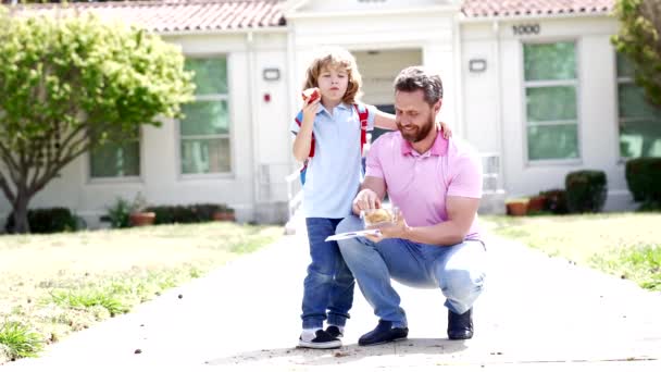 Mutlu baba ve çocuk öğle yemeklerini okul dışında yer, yavaş çekimde, aile — Stok video