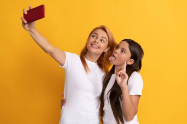 Mutlu havalı anne ve çocuk telefonda selfie çekiyor, içerik yapıcı.
