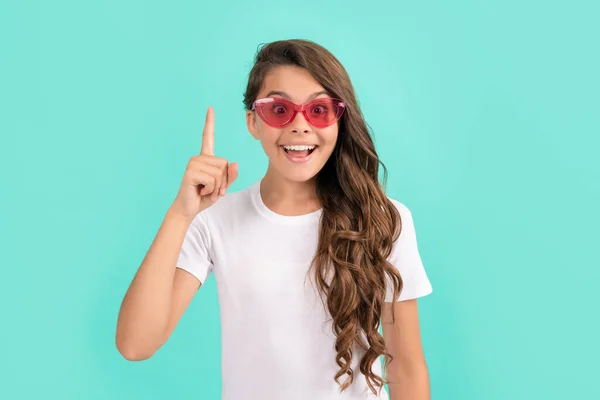 Criança feliz cabelo longo em óculos de sol estilo casual inspirado com ideia sobre fundo azul, inspiração. — Fotografia de Stock