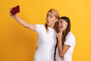 Mutlu anne ve kızın aile portresi. Akıllı telefondan selfie çekiyor. Modern hayattan.