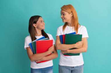 Mutlu özel öğretmen ve çocuk ellerinde kitaplarla birbirlerine bakıyorlar.