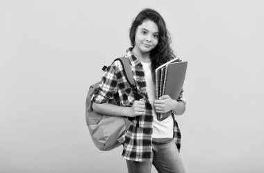 Sırt çantası, defterleri ve eğitimle çalışmaya hazır gülümseyen liseli kız.