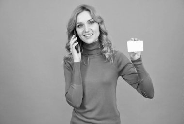 Cep telefonunda konuşan mutlu kadın fotokopi alanı gri arka planı ve bankacılık için kredi kartı gösteriyor.