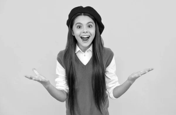 Verrast tiener school meisje in frans baret op gele achtergrond, verrassing — Stockfoto
