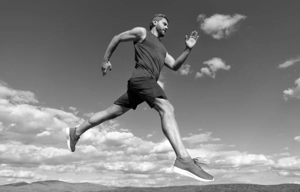 Спортсмен спринтер з м'язистим тілом, що працює в спортивному одязі на фоні неба, витривалість . — стокове фото