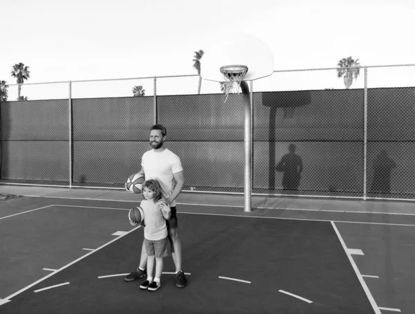 Feliz papá e hijo niño jugar baloncesto con pelota en el patio de recreo, feliz fin de semana — Foto de Stock