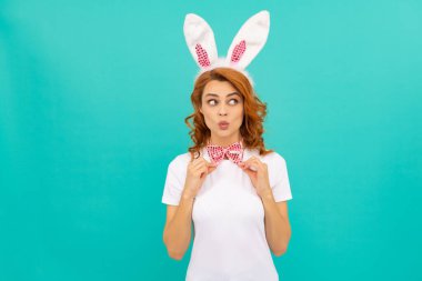 Tavşan kulaklı neşeli Paskalya kızı ve mavi arka planda papyon.