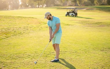 Golf sopası ve golf sopasıyla şapkalı bir golfçü.