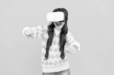 Mutlu genç kız kablosuz sanal gerçeklik gözlüğü takıyor. VR kulaklıkla. Çocuk video oyunu oynuyor. Dijital gelecek