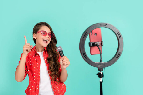 детская певица поет песню на музыкальном видео блоге блог онлайн с микрофоном, вокал.