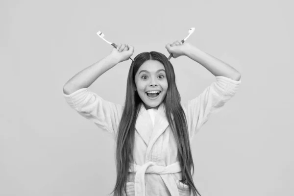 Divertido feliz adolescente chica en casa terry albornoz celebrar cepillo de dientes como demonios cuernos, rutina diaria —  Fotos de Stock