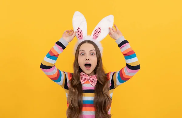 Niño pascua sorprendido en orejas de conejo y pajarita sobre fondo amarillo —  Fotos de Stock