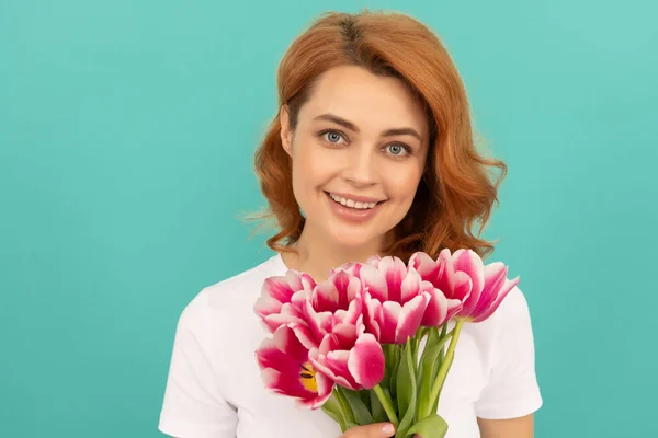Šťastná žena s tulipán kytice na modrém pozadí. Den matek — Stock fotografie