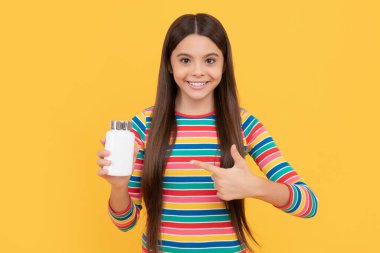 Mutlu çocuk doğal gıda katkı maddelerini işaret ediyor ya da kavanozda vitamin hapları, sağlık