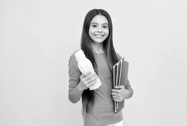 Glad barn flicka hålla anteckningsblock för läxor och juice flaska, lunch — Stockfoto