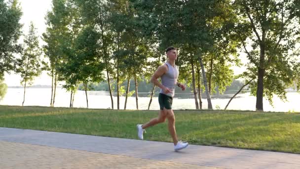 Athletic man running in sunrise park outdoor, anaerobic load — Stock Video