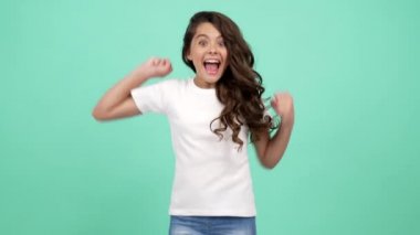 Mutlu çocuk portresi. Uzun kıvırcık saçlar. Sevinç ve mutluluk içinde zıplıyor.