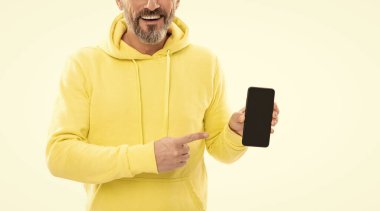 Kesilen adam akıllı telefon ekranını gösteriyor. Kopyalama alanı üzerinde işaret ediyor. Beyazda izole edilmiş, reklam..