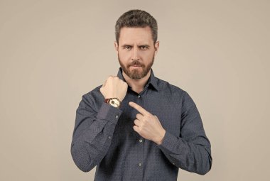 Dakikliğin zerafeti. Sakallı adam kol saatini işaret ediyor. Dakiklik kavramı. İş zamanı