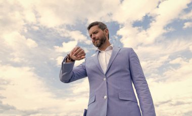 Mavi takım elbiseli ve kol saati takan bir adam. Dakiklik. yönetici kontrol zamanı.