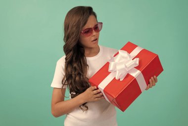 Şu anki kutusu olan ciddi bir çocuk. Genç kız doğum günü hediyesi veriyor. Güneş gözlüklü çocuk paylaşım kutusu