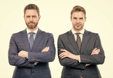 Takım elbiseli iki kendine güvenen iş adamı el ele tutuşup, resmi kıyafetlerini giyiyorlar.