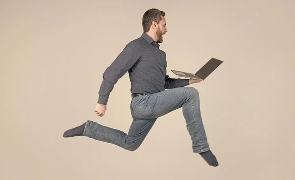 Удивленный энергичный человек работает во время работы в Интернете на ноутбуке спешите за покупками, покупками. — стоковое фото