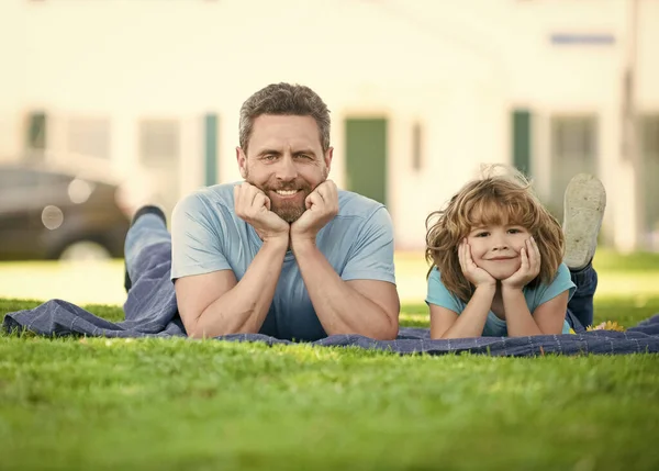 행복 한 아들 이자 아버지인 사람은 옥외의 풀 위에서 가족 여가를 즐기며, 담요 위에서 휴식을 즐긴다 — 스톡 사진