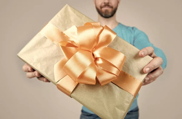 Подарок или коробка с подарком крупным планом в руках обрезанного человека, избирательный фокус, поздравления — стоковое фото
